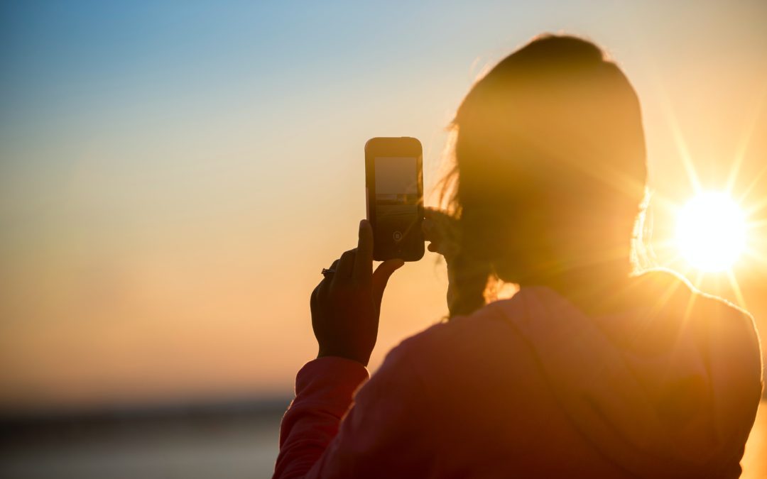 Foto van vrouw die foto maakt van mooie zonsondergang