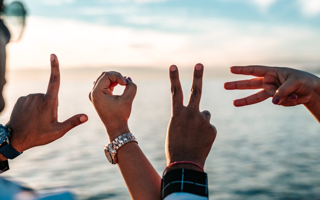 vier handen die samen het woord 'love' uitbeelden